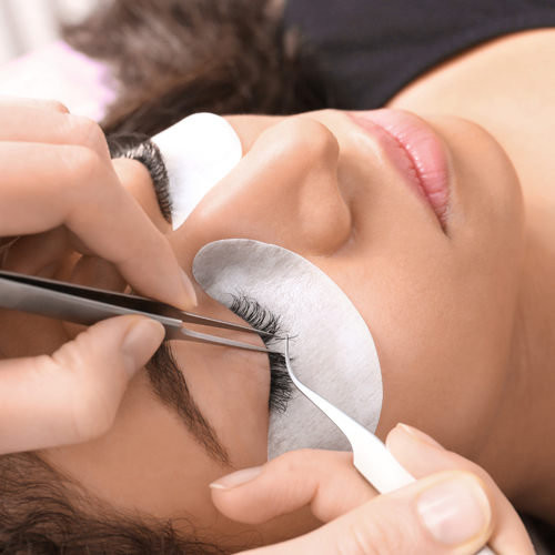 artist applying eyelash extensions on client